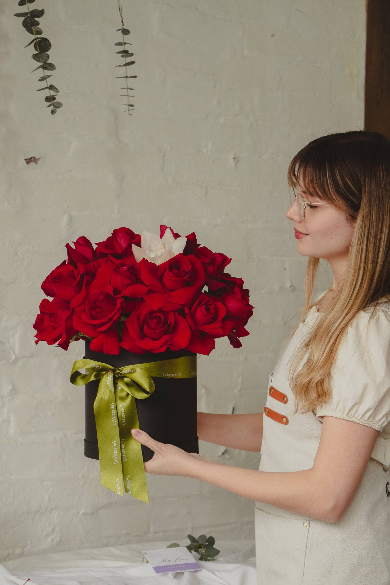 Julieta, caja con rosas rojas y orquidea.