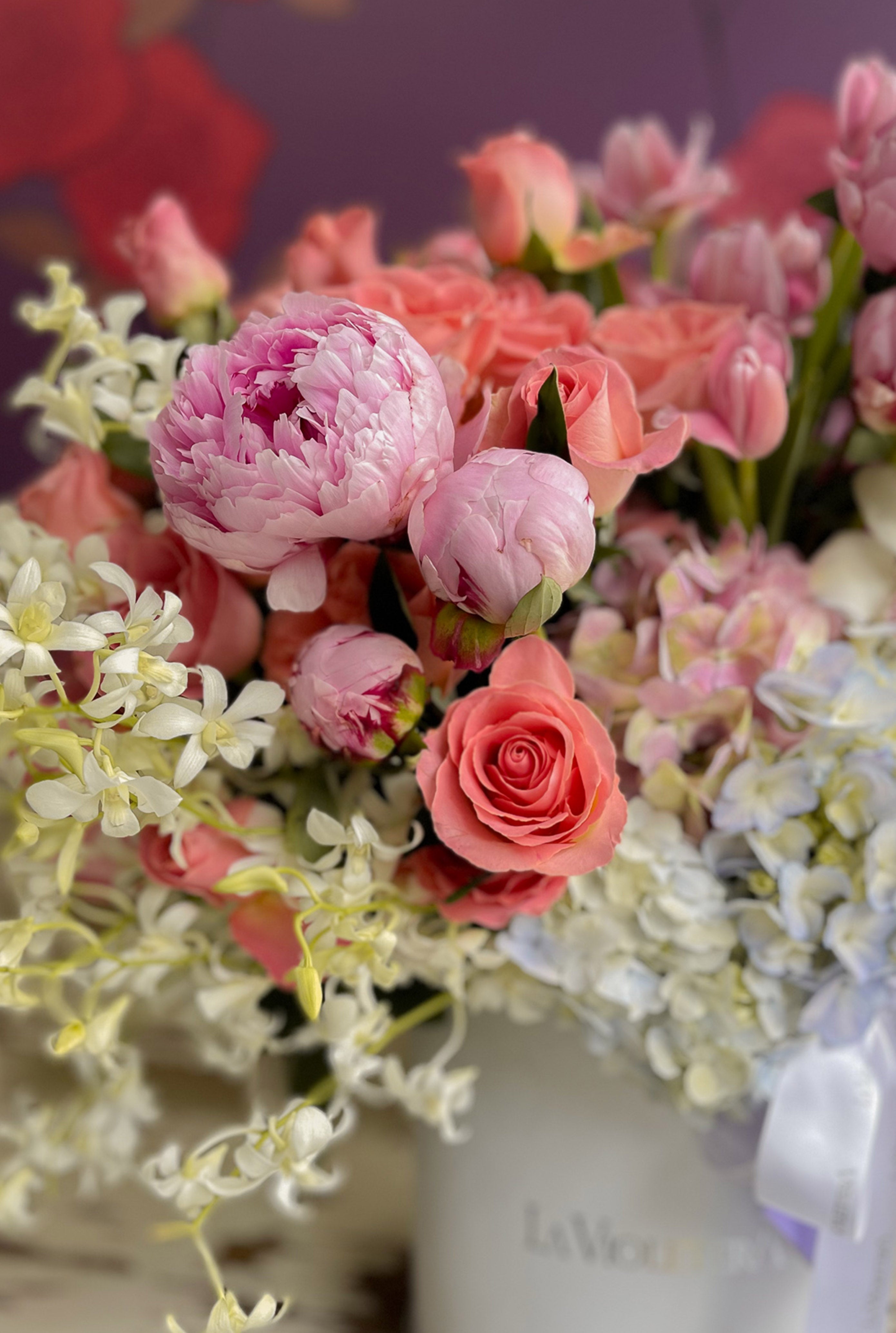 Pia, diseño en caja con peonías, orquídeas , rosas .