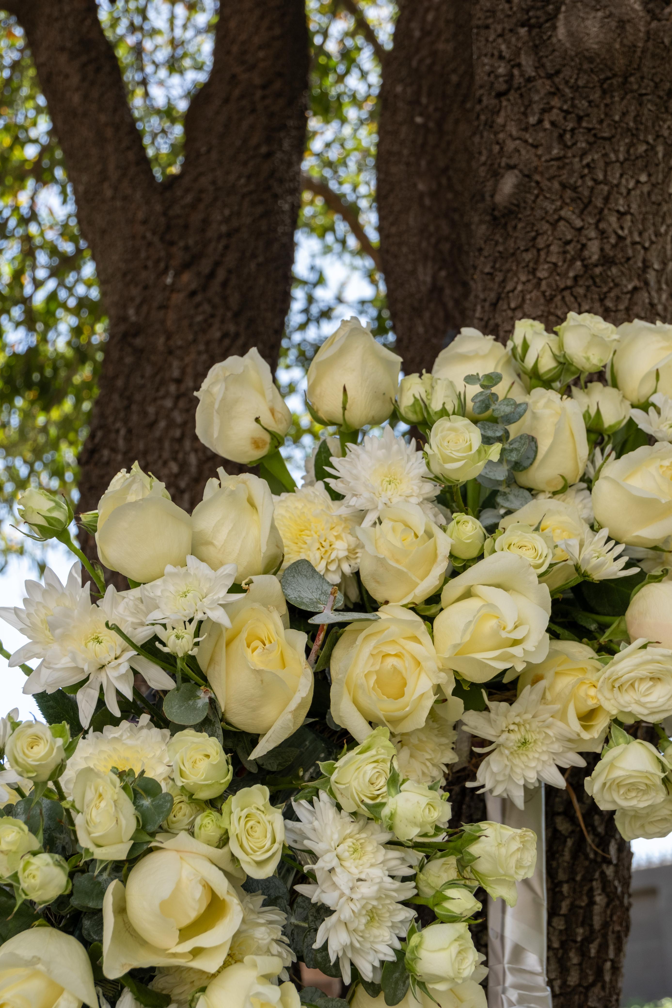 Consuelo, corona con rosas y variedad de flores naturales