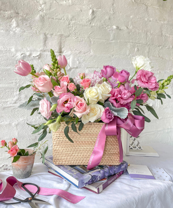 Tania, cesta con exquisita variedad de flores rosadas.