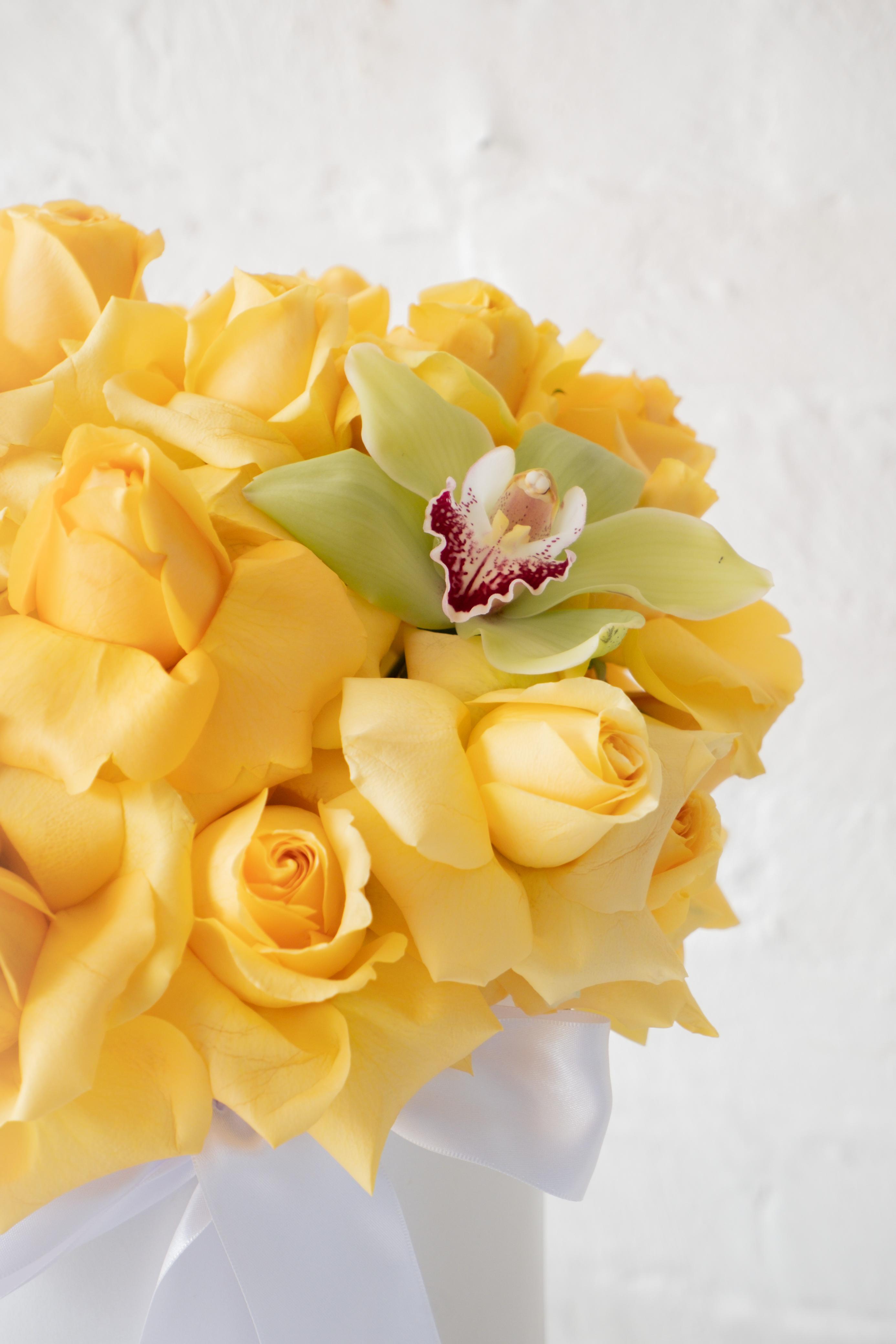 Abril, rosas amarillas con orquídea.
