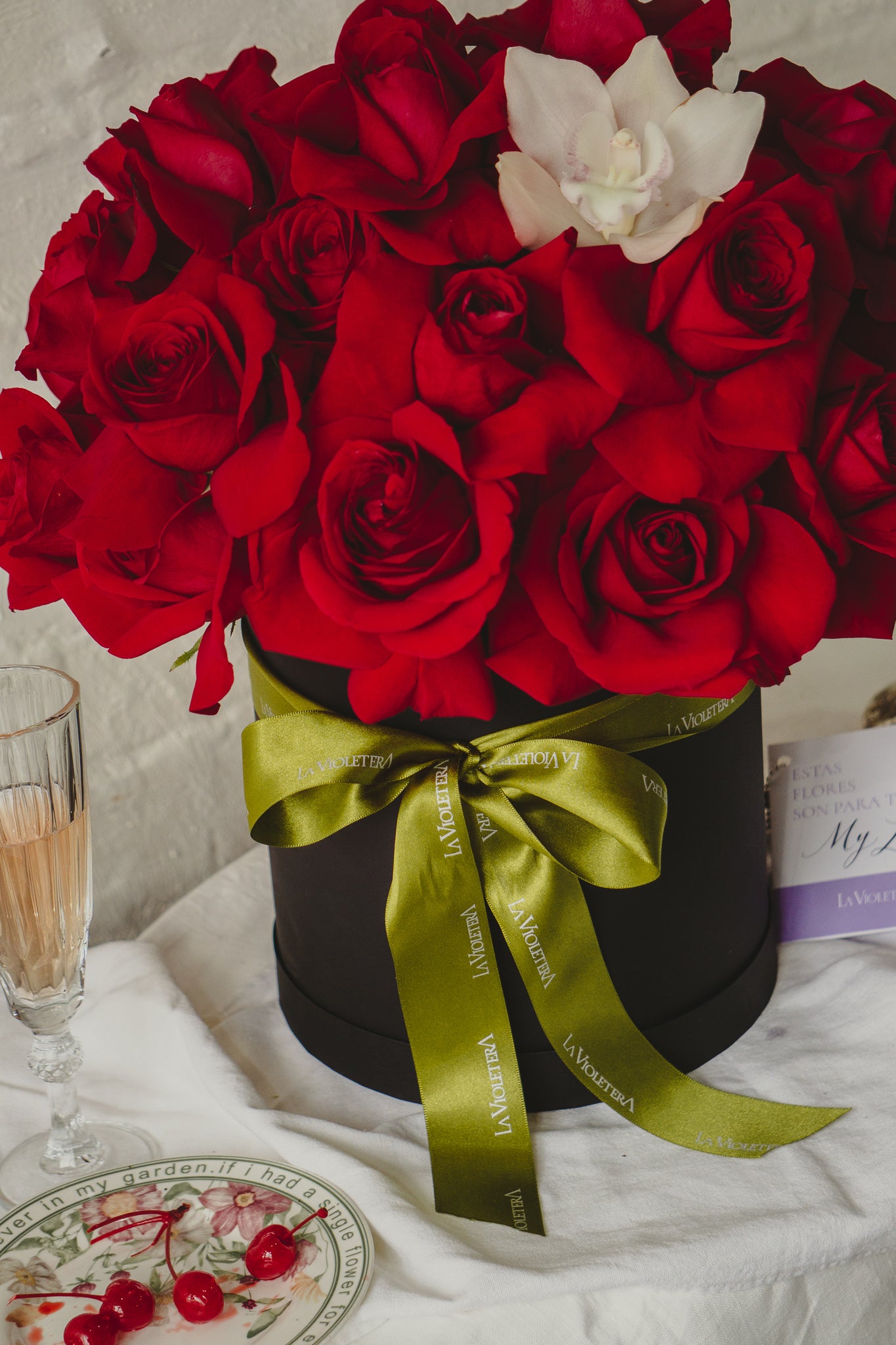 Julieta, caja con rosas rojas y orquidea.