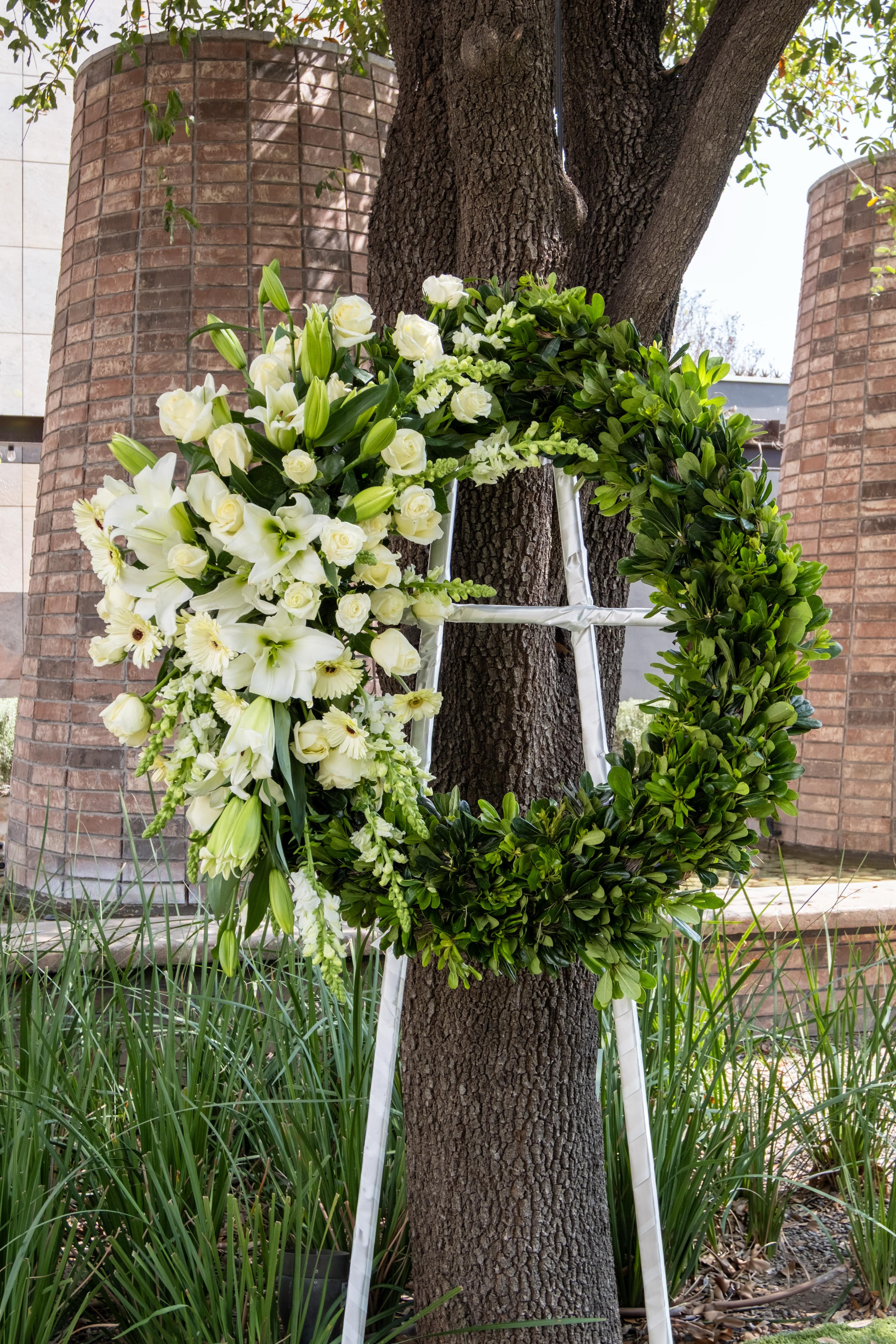 Eternidad, corona de flores blancas combinado con follajes.