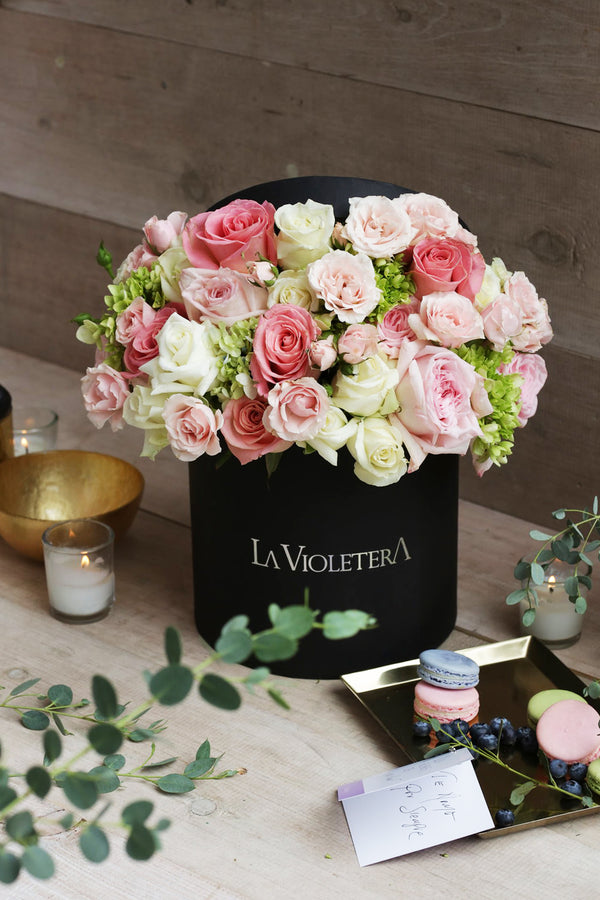 Mia, caja negra con rosas y mini rosas en color pastel.