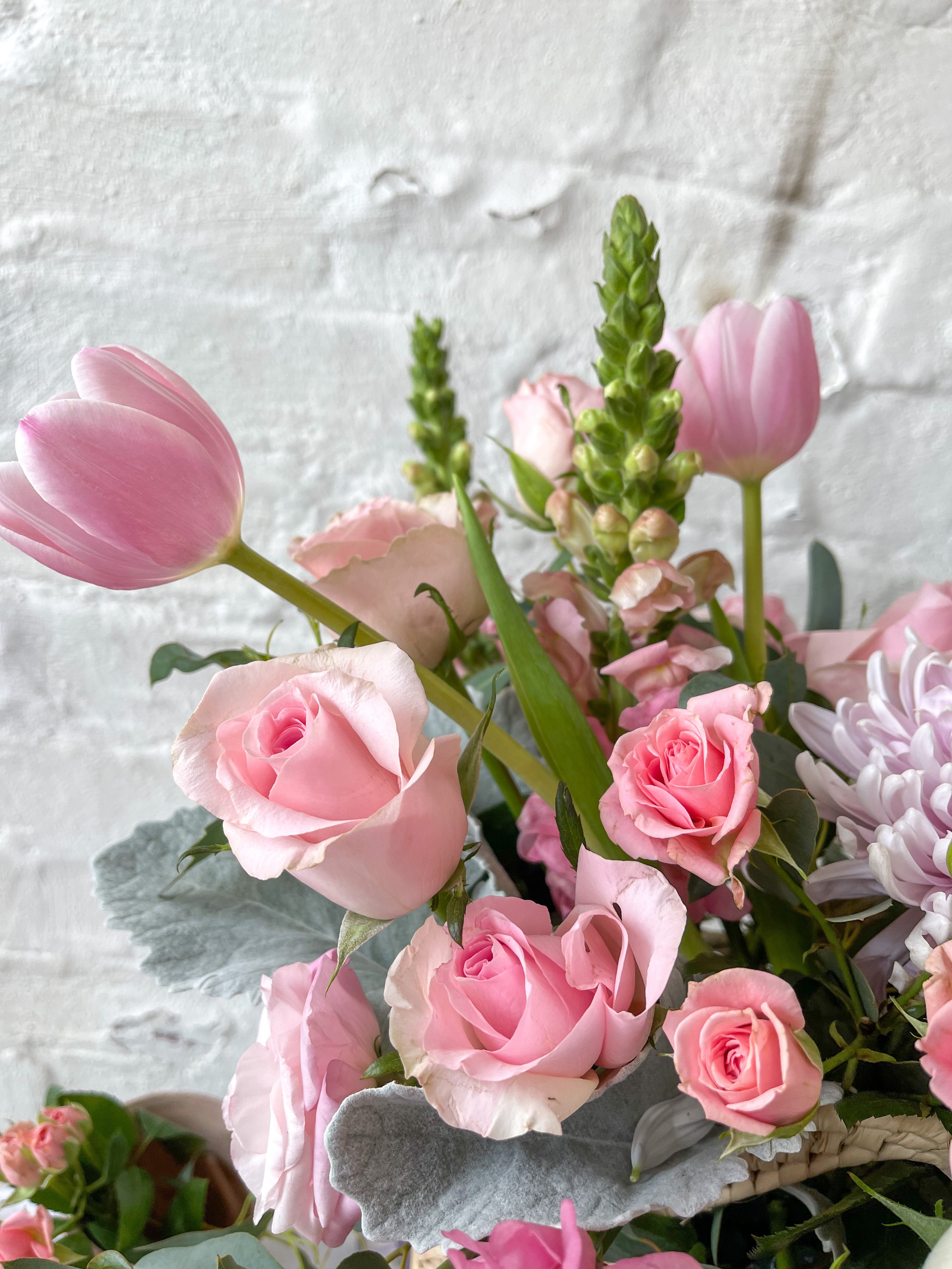 Tania, cesta con exquisita variedad de flores rosadas.