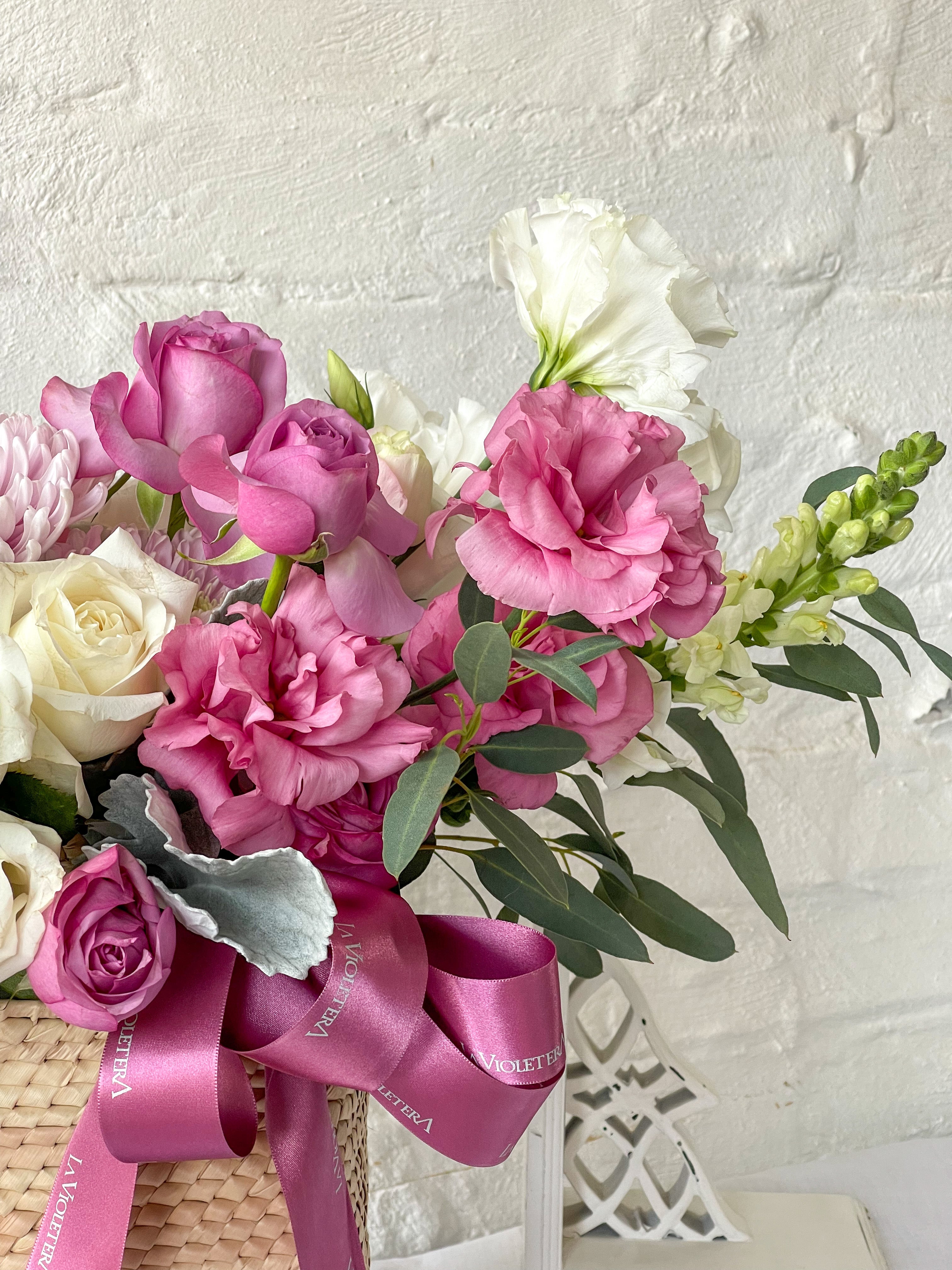 Tania, cesta con exquisita variedad de flores rosadas.